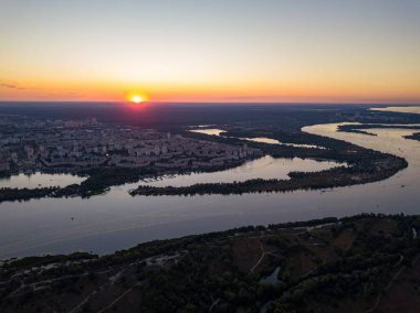 Hava aracı görüntüsü. Dinyeper Nehri ve Kiev şehrinin üzerinde gün batımı.