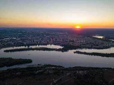Hava aracı görüntüsü. Dinyeper Nehri ve Kiev şehrinin üzerinde gün batımı.