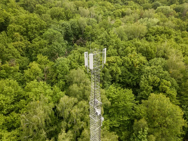 Aerial drone detail view. Cellular tower on the background of a green forest.