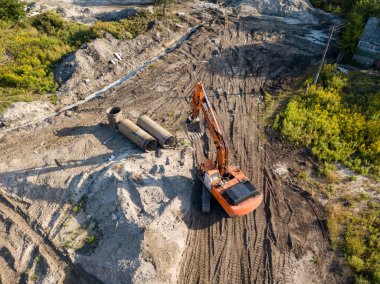 Hava aracı görüntüsü. Köprü inşaatında turuncu kazıcı.