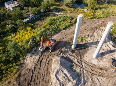 Hava aracı görüntüsü. Köprü inşaatında turuncu kazıcı.