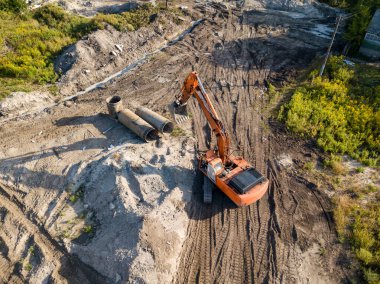 Hava aracı görüntüsü. Köprü inşaatında turuncu kazıcı.
