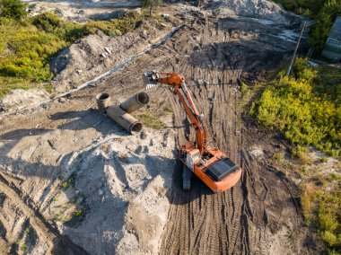 Hava aracı görüntüsü. Köprü inşaatında turuncu kazıcı.