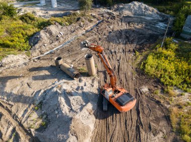 Hava aracı görüntüsü. Köprü inşaatında turuncu kazıcı.
