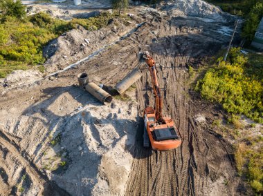 Hava aracı görüntüsü. Köprü inşaatında turuncu kazıcı.