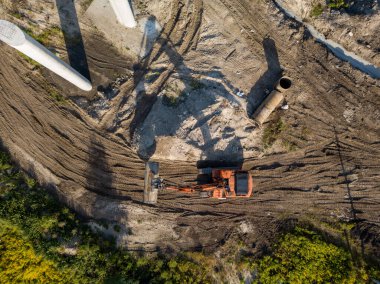Hava aracı görüntüsü. Köprü inşaatında turuncu kazıcı.