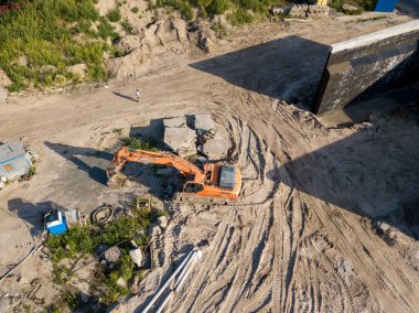 Hava aracı görüntüsü. Köprü inşaatında turuncu kazıcı.