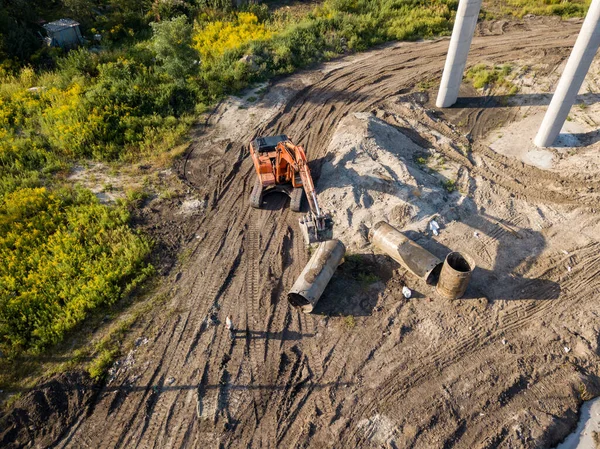 Hava aracı görüntüsü. Köprü inşaatında turuncu kazıcı.