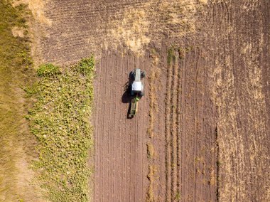 Hava aracı görüntüsü. Traktör patates tarlasında patates topluyor..