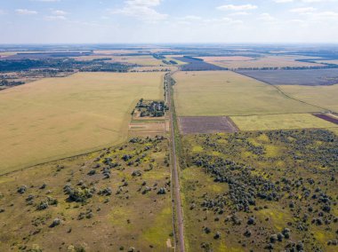 Hava aracı görüntüsü. Nadir çalılarla dolu bir çayırdan geçen demiryolu..