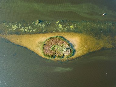 Hava aracı görüntüsü. Nehirdeki küçük yuvarlak ada. Adada çalılıklar var. Adanın yakınında dikdörtgen bir sığlık var..