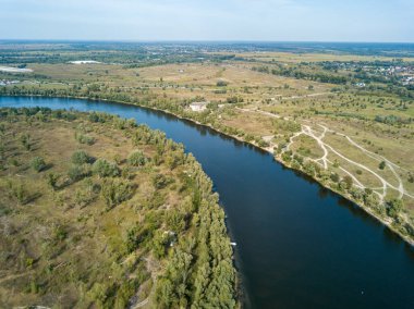 Hava aracı görüntüsü. Yeşil çayırlar arasında geniş bir nehrin kıvrımı. Güneşli yaz günü.