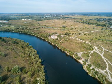Hava aracı görüntüsü. Yeşil çayırlar arasında geniş bir nehrin kıvrımı. Güneşli yaz günü.
