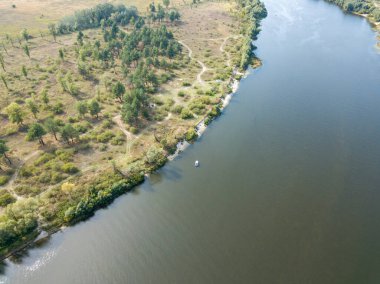 Hava aracı görüntüsü. Yeşil çayırlar arasında geniş bir nehrin kıvrımı. Güneşli yaz günü.