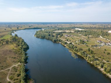 Hava aracı görüntüsü. Yeşil çayırlar arasında geniş bir nehrin kıvrımı. Güneşli yaz günü.