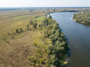 Hava aracı görüntüsü. Yeşil çayırlar arasında geniş bir nehrin kıvrımı. Güneşli yaz günü.