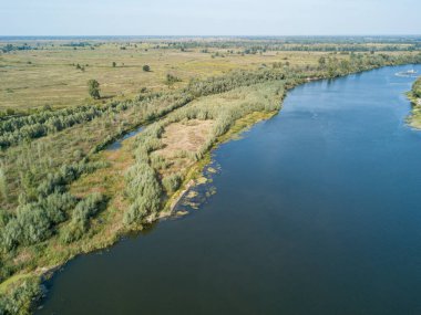 Hava aracı görüntüsü. Yeşil çayırlar arasında geniş bir nehrin kıvrımı. Güneşli yaz günü.