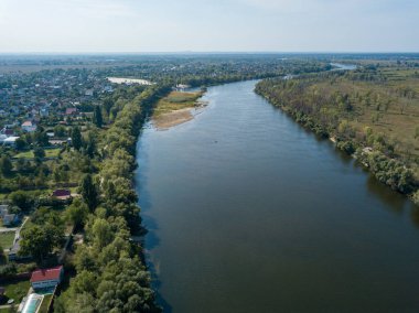 Hava aracı görüntüsü. Yeşil çayırlar arasında geniş bir nehrin kıvrımı. Güneşli yaz günü.