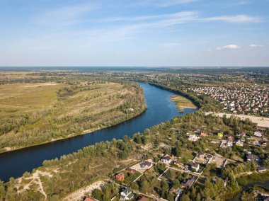 Hava aracı görüntüsü. Yeşil çayırlar arasında geniş bir nehrin kıvrımı. Güneşli yaz günü.