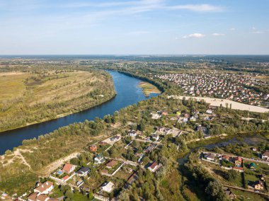 Hava aracı görüntüsü. Yeşil çayırlar arasında geniş bir nehrin kıvrımı. Güneşli yaz günü.