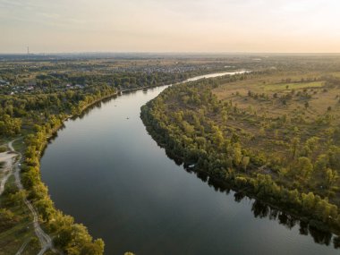 Hava aracı görüntüsü. Yeşil çayırlar arasında geniş bir nehrin kıvrımı. Güneşli yaz günü.