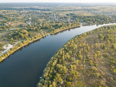 Hava aracı görüntüsü. Yeşil çayırlar arasında geniş bir nehrin kıvrımı. Güneşli yaz günü.