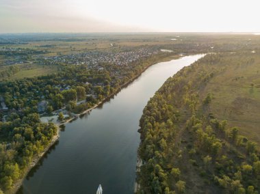 Hava aracı görüntüsü. Yeşil çayırlar arasında geniş bir nehrin kıvrımı. Güneşli yaz günü.