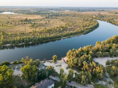 Hava aracı görüntüsü. Yeşil çayırlar arasında geniş bir nehrin kıvrımı. Güneşli yaz günü.