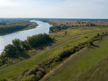 Yeşil çayırların arasındaki toprak yol. Yaz güneşli bir gün. Hava aracı görünümü.