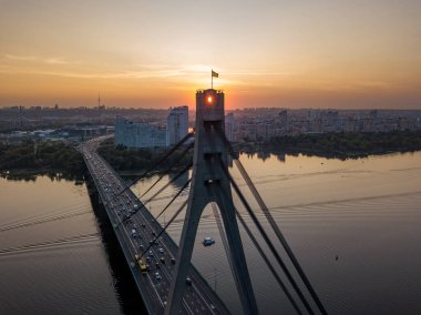 Hava aracı görüntüsü. Otomobil Kuzey Köprüsü Kiev 'de gün batımında.