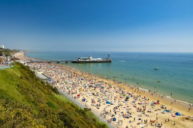 Altın kumsalları ve mavi-yeşil denizler Bournemouth arasındaki Poole Dorset Sahili boyunca güneş ışığı yanar