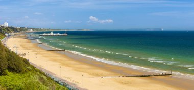 Altın kumsalları ve mavi-yeşil denizler Bournemouth arasındaki Poole Dorset Sahili boyunca güneş ışığı yanar