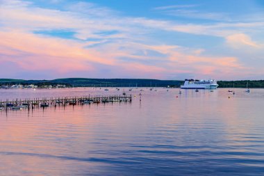 Deep colours of orange and red in the skies over a Poole Harbour jetty near Sandbanks clipart