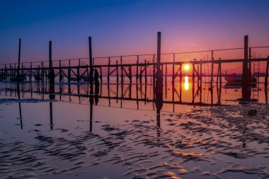 Turuncu ve kırmızı gökyüzü Sandbanks yakınındaki bir Poole Harbour iskele üzerinde derin renkler