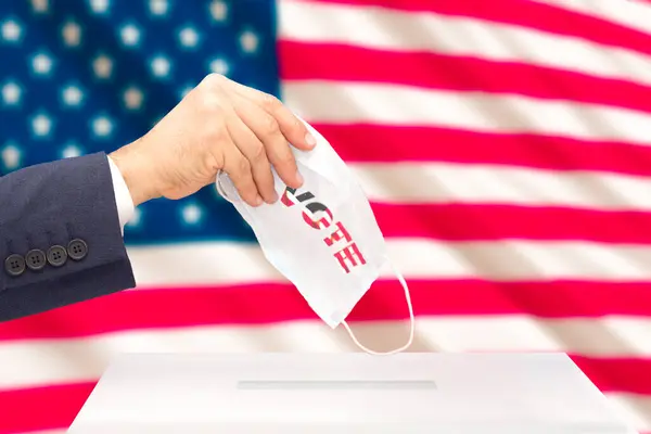 医療面での米国大統領選挙での男性の手の投票は その背後にある米国の旗をマスクします 選択的焦点 — ストック写真