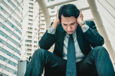 Merdivenlerde oturan genç depresif iş adamı