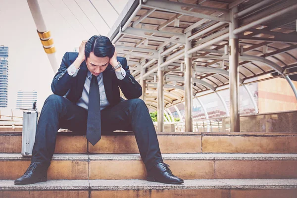 Merdivenlerde oturan genç depresif iş adamı