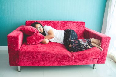 Evdeki kanepede uyuyan genç kadın.