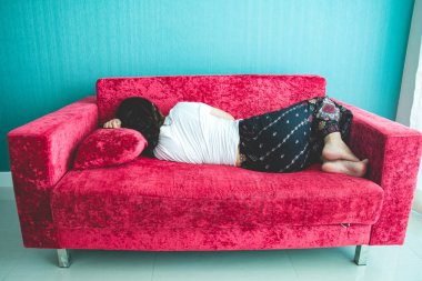 Evdeki kanepede uyuyan genç kadın.