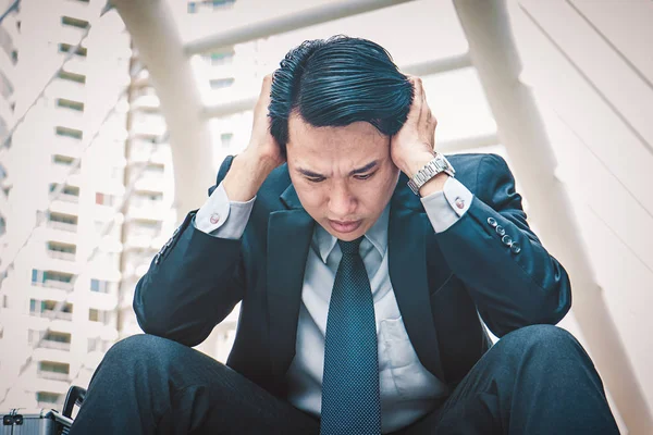 Merdivenlerde oturan genç depresif iş adamı