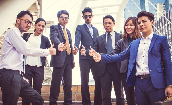 Başarılı iş adamları başparmak yukarı ve gülümseyen, iş takım ile