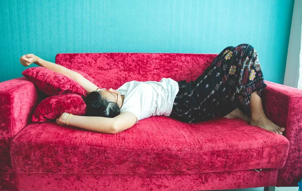 Evdeki kanepede uyuyan genç kadın.
