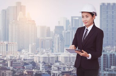 Genç iş kadını takım elbise ve koruyucu kask dijital tablet kullanma