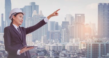 Genç iş kadını takım elbise ve koruyucu kask dijital tablet kullanma