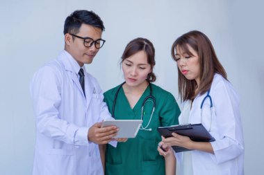 Doktor ve hemşire hasta bilgilerini tablet cihaza kontrol