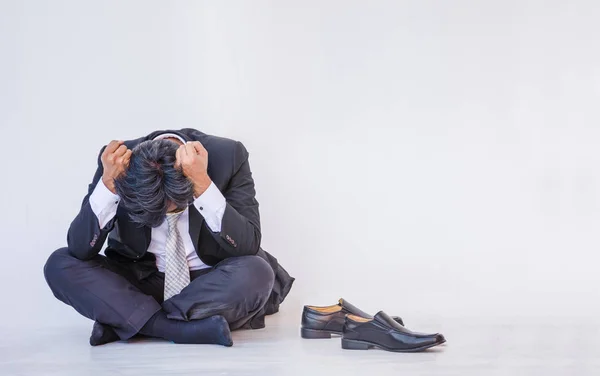 Depressed businessman sitting on the floor