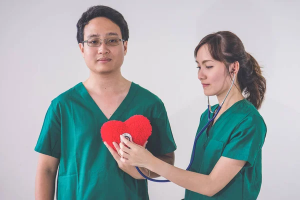 Médico Con Estetoscopio Examinando Corazón Rojo —  Fotos de Stock