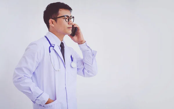 Młody Lekarz Mężczyzna Ubrany Biały Płaszcz Pomocą Smartfona — Zdjęcie stockowe