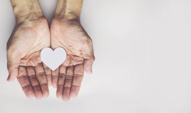 Yaşlı adam beyaz arka plan üzerinde kalp şekli tutan eller. Sağlık sigortası ya da aşk kavramı