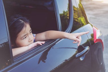küçük kız pencereden bakıyor. 
